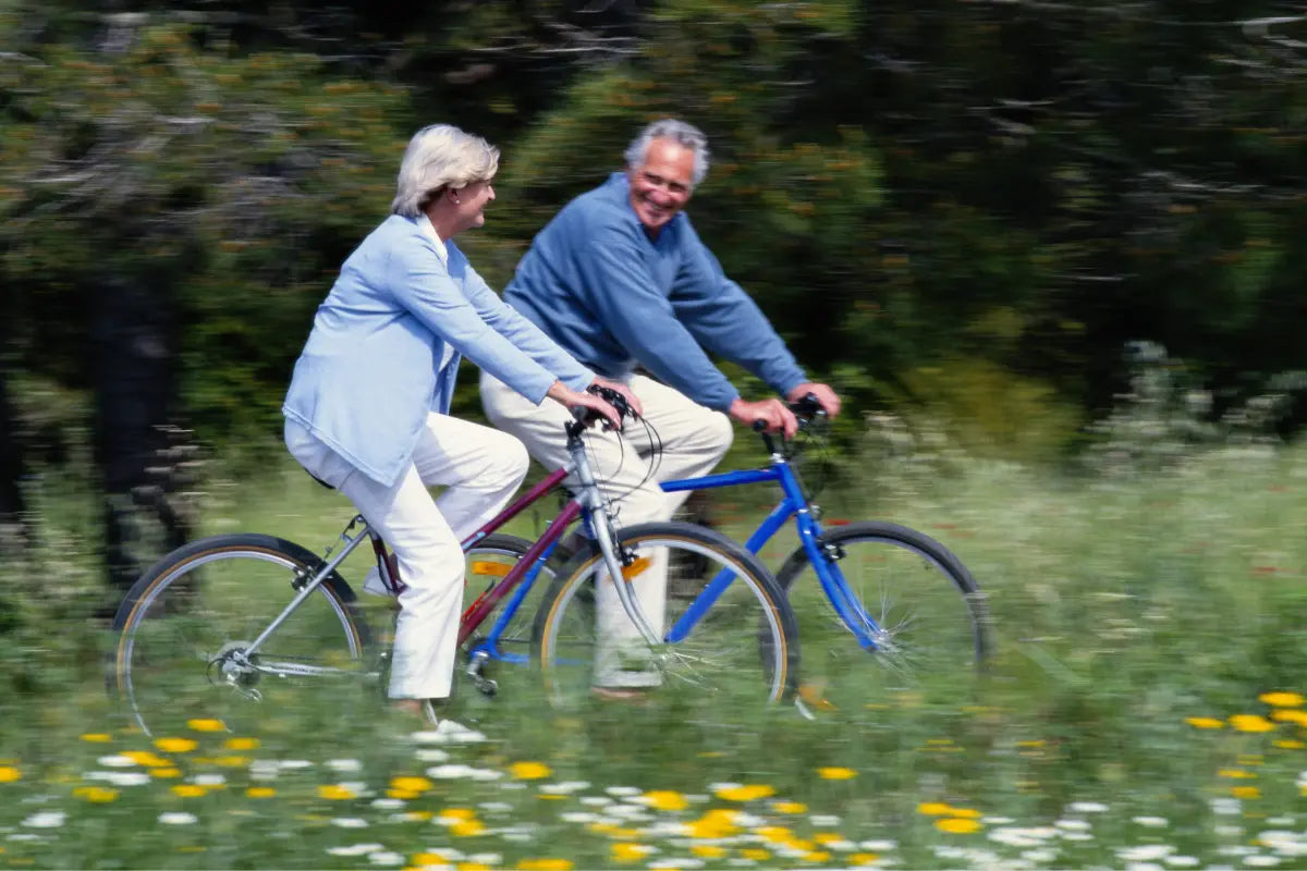 Äldre par på cykel i höstljus